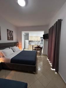 a bedroom with a bed and a dining room at Ksamil Apartament Sela in Ksamil