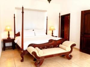 a bedroom with a large bed and a bench at Panáveda Ayurvedic Wellness Centre in El Creo +24 photos