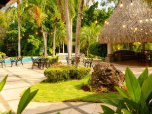 a patio with tables and chairs and a pool at Panáveda Ayurvedic Wellness Centre in El Creo
