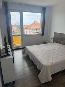 a bedroom with a bed and a desk with a computer at Уютът на Ясен in Yasen