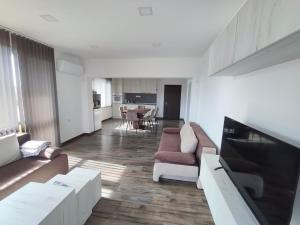 a living room with a couch and a flat screen tv at Уютът на Ясен in Yasen