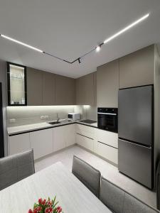 a large kitchen with a table and a refrigerator at Sako Apartaments 2 in Golem +9 photos