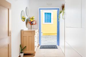 a hallway with a yellow door and a vase of flowers at Twelve 12 Islands in Symi