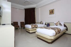 a hotel room with two beds in a room at Hotel O Midtown in Raipur
