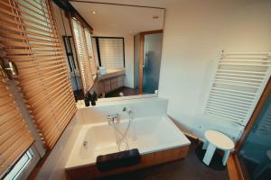 a bathroom with a tub and a toilet and a mirror at appartement 103m2 près de Megève, face à télécabine la Princesse,2 chambres , garage, local à ski in Demi-Quartier +45 photos