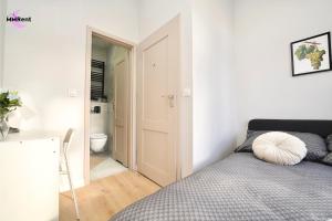 a bedroom with a bed and a bathroom with a toilet at MMRent Grape Room in Gdańsk