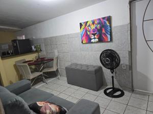 a living room with a fan and a painting on the wall at Q02 custo-benefício in São Luís