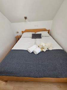 a bedroom with a large bed with two stuffed animals on it at Apartma Brin Rogla in Zreče