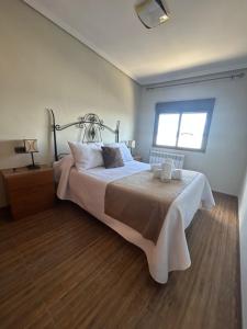 a bedroom with a large bed and a window at Casa Enmedio in Iznatoraf
