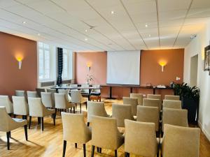 a conference room with chairs and a podium at Le Grand Hôtel de Mayenne - Logis hôtels restaurant in Mayenne