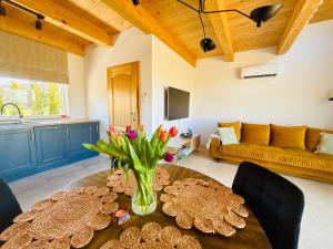 a living room with a table with a vase of flowers at Słoneczny Stok in Małastów