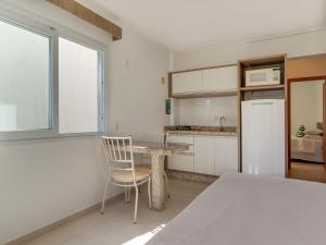 a kitchen with a table and a chair at Villa Maciel Bombinhas in Bombinhas +10 photos