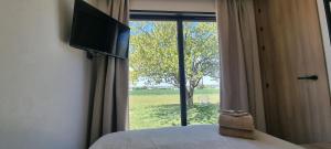 a bedroom with a bed and a window with a television at Gîte isolé avec terrasse in Laignes