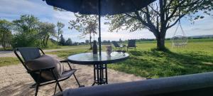 a table and chairs under an umbrella in a field at Gîte isolé avec terrasse in Laignes