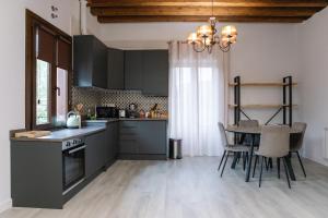 a kitchen with black cabinets and a table with chairs at Tu Casa San Marcos - Vistas al Alcázar - Ideal estancias tranquilas in Segovia