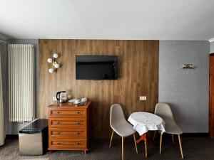 a room with two chairs and a table and a tv at Villa Akacja in Łeba