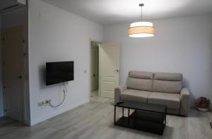 a living room with a chair and a television at Tu Casa San Marcos - Vistas al Alcázar - Ideal estancias tranquilas in Segovia