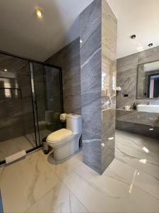 a bathroom with a toilet and a shower and a sink at Hotel Casa Agave in Baños +43 photos
