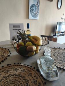 a bowl of fruit and a bottle of wine on a table at SeaShell apartment Sea View, Castle View 200metres from the Beach in Sitia