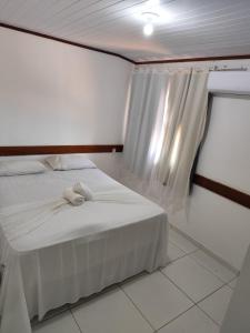 ein Schlafzimmer mit einem Bett, auf dem ein Stofftier liegt in der Unterkunft Morro da Saudade in Cayru