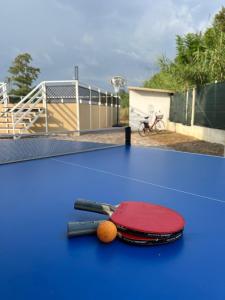 a tennis racket and ball on a blue table at The happy smile villa in Bella Farnia