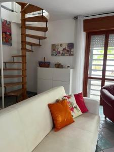a living room with a white couch with colorful pillows at The happy smile villa in Bella Farnia +67 photos