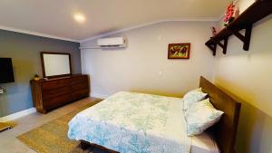a bedroom with a bed and a dresser and a mirror at Ensuite Condo Aruba in Palm-Eagle Beach