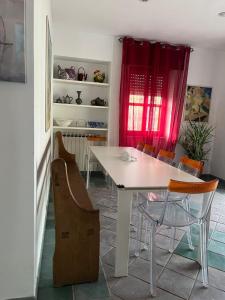 a dining room with a white table and chairs at The happy smile villa in Bella Farnia