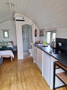 a kitchen and living room in a tiny house at Grange Beck Farm Glamping in Kildwick