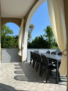 a patio with a table and chairs and an umbrella at The happy smile villa in Bella Farnia