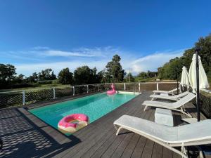 a swimming pool with chaise lounge chairs and a swimming poolvisor at The happy smile villa in Bella Farnia