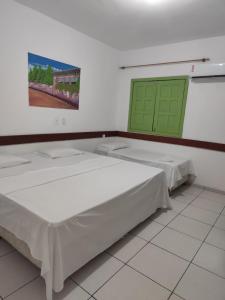 zwei Betten in einem Zimmer mit einer grünen Tür in der Unterkunft Morro da Saudade in Cayru + 5 Fotos