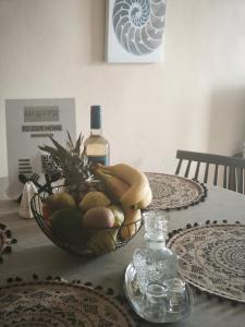 a bowl of fruit and a bottle of wine on a table at SeaShell apartment Sea View, Castle View 200metres from the Beach in Sitia