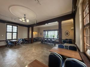 a large room with tables and chairs and windows at BP Hostel Gdynia in Gdynia