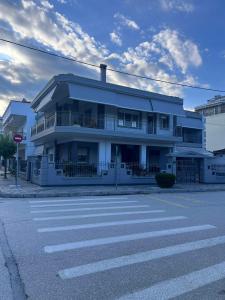 a white building on a street with a crosswalk at Dimitris Apartment in Karditsa