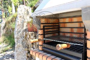 a barbecue with a stack of fire wood at Quinta das Flores da Mãe in Folhada