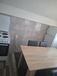 a kitchen with a stove and a wooden table at Vikendica Popadić in Vukovina
