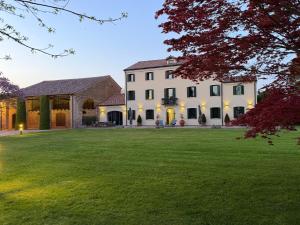 a large white house with a large yard at Il Salice Country Luxury in Due Carrare