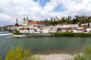 a group of buildings next to a river at Spacious 80 m2 Apartment I 3 Rooms I Up to 8 Guests I Near Train Station in Steyr
