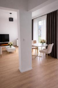 a living room with a table and chairs and a television at PikApart in Olsztyn