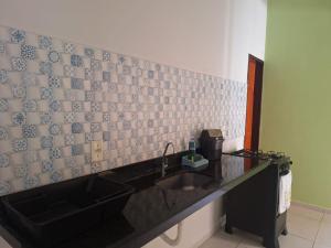 a kitchen with a sink and a tiled wall at Casa charmosa, e bem localizada in Juazeiro do Norte +13 photos