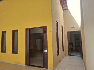a hallway with two doors and a yellow wall at Casa charmosa, e bem localizada in Juazeiro do Norte