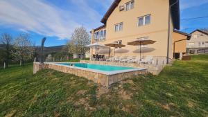 a house with a swimming pool in the yard at Villa Green Oasis Swimming Pool in Sarajevo