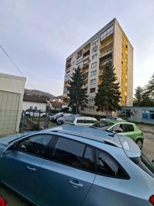 a blue car parked in a parking lot in front of a building at Index 1 in Hiseti