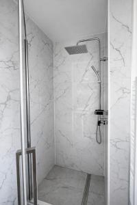 a bathroom with a shower with white marble walls at VE Apartments Colbitz in Kolbitz