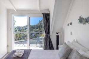 a bedroom with a bed with a view of a balcony at Premium Seaview Villa in Waiheke Island