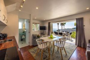 a kitchen and living room with a table and chairs at Premium Seaview Villa in Waiheke Island