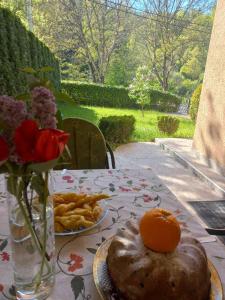 a table with a plate of food and an orange on it at Velez IVANOVI DVORI in Jošanička Banja