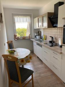 a kitchen with a small table and a table and chairs at Ferienwohnung in Ostseenähe 1 in Velgast