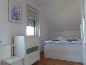 a white bedroom with a bed and a window at Ferienwohnung in Ostseenähe 1 in Velgast